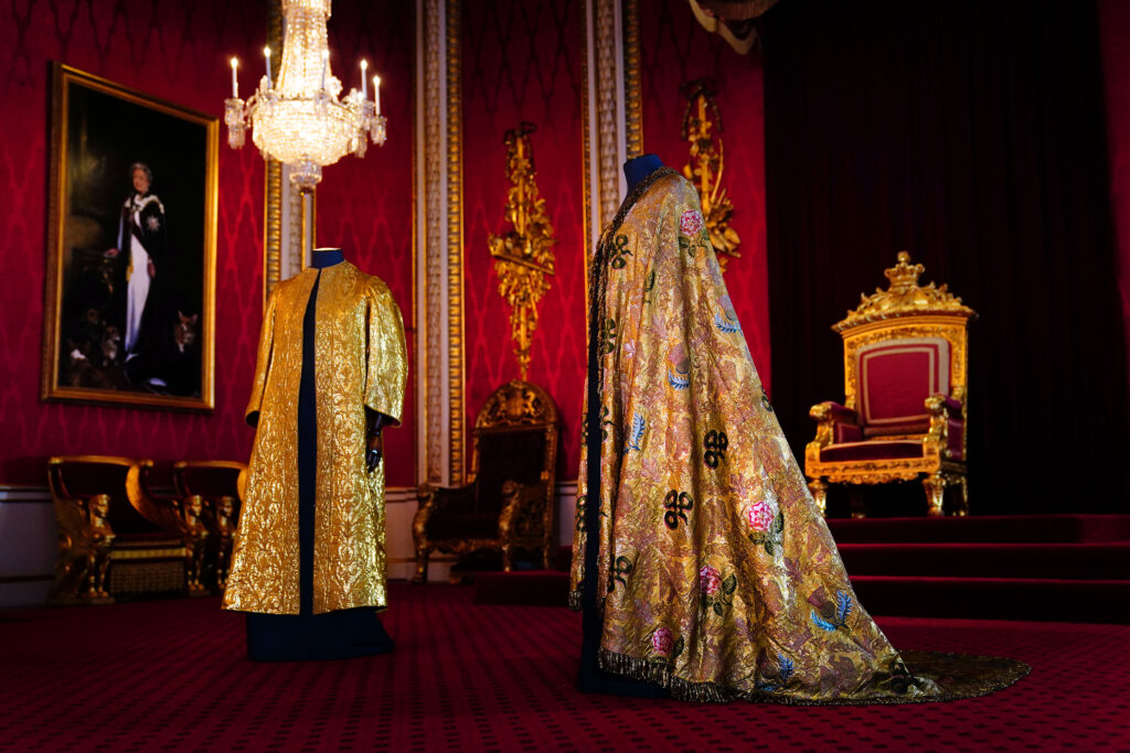 The Coronation Vestments, comprising of the Supertunica (left) and the Imperial Mantle (Robe Royal) (right), displayed in the Throne Room at Buckingham Palace, London. The vestments will be worn by King Charles III during his coronation at Westminster Abbey