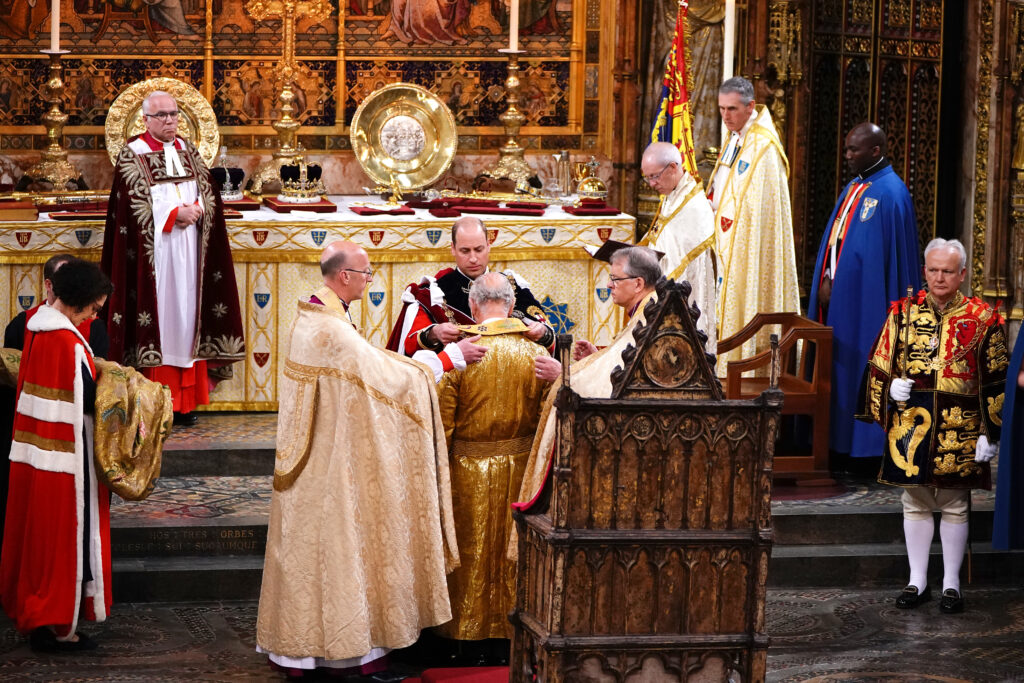 The Prince of Wales puts the Stole on King Charles III after he has been vested in the Supertunica and Robe Royal (Imperial Mantle) during his coronation ceremony.