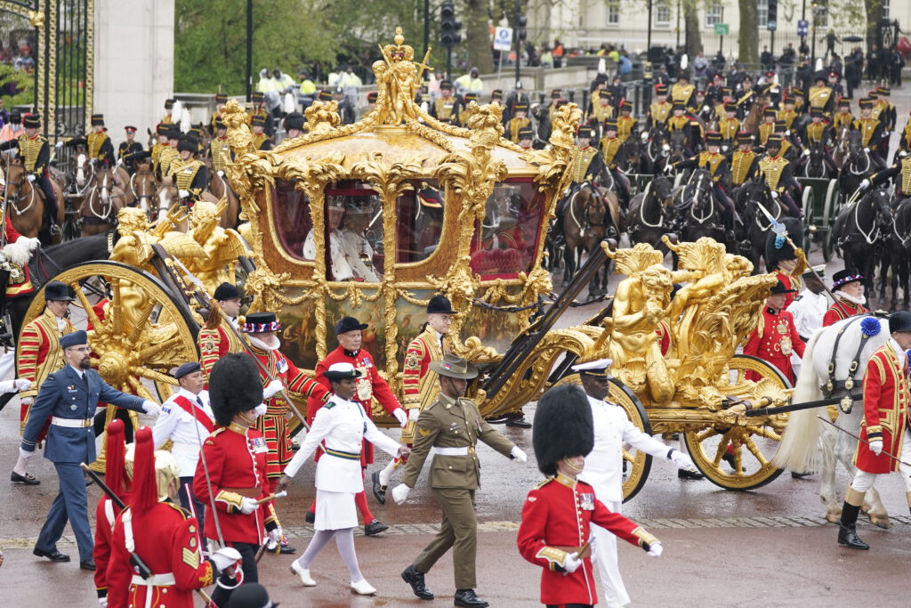 King Charles III and Queen Camilla are carried in the Gold State Coach, pulled by eight Windsor Greys, in the Coronation Procession as they return to Buckingham Palace, London, following their coronation ceremony