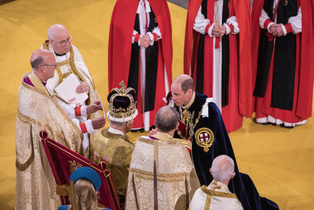 King Charles III wearing St Edward's Crown, receives the Prince of Wales, during his coronation at Westminster Abbey, London.