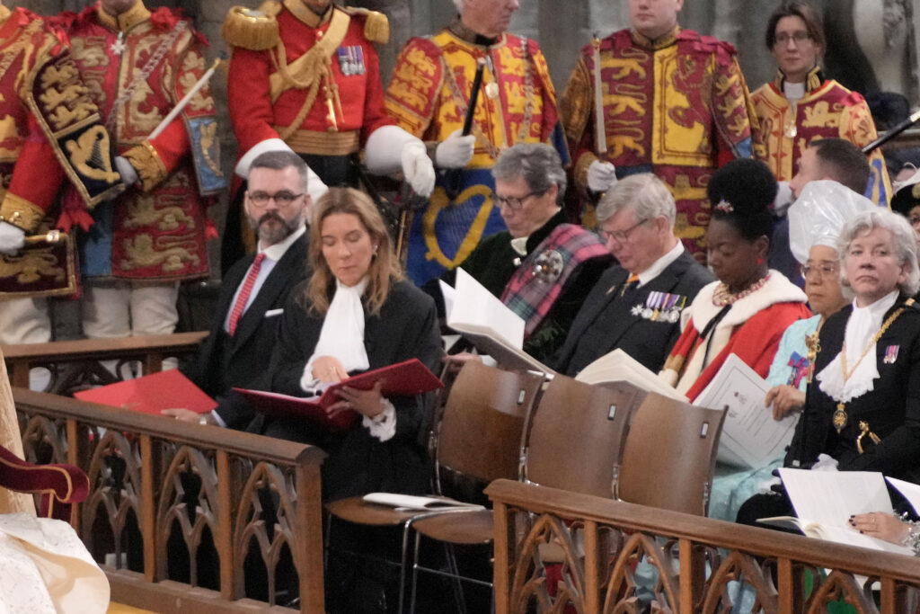 Clerk of the Crown in Chancery, Antonia Romeo, recording the Coronation proceedings. Behind her are the Earl of Crawford and Balcarres, and the Earl of Erroll