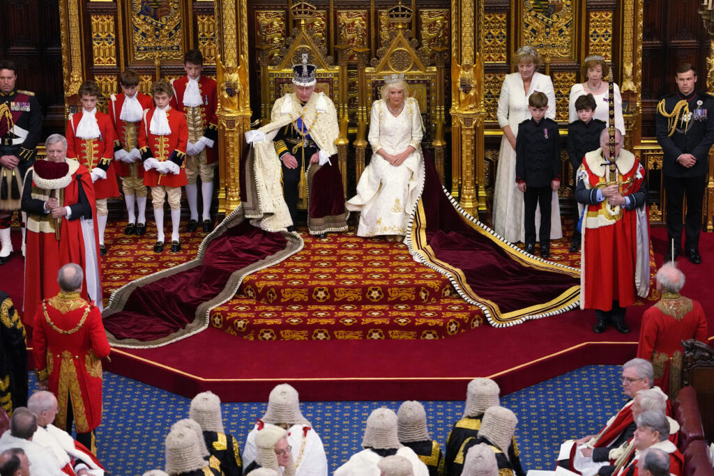 King Charles III, wearing the Imperial State Crown, sits besides Queen Camilla in the George IV State Diadem during the State Opening of Parliament, in the House of Lords at the Palace of Westminster in London